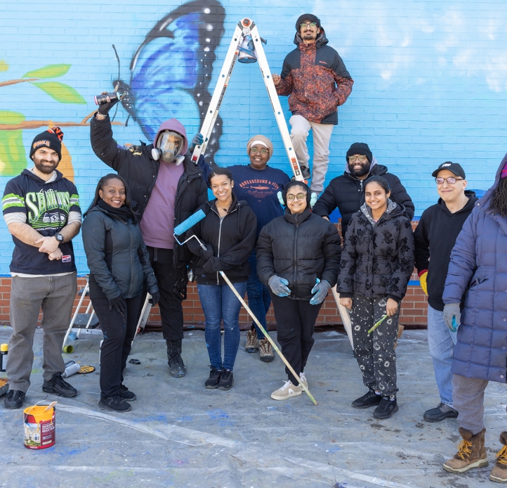 Students stand in front of the mural they painted
