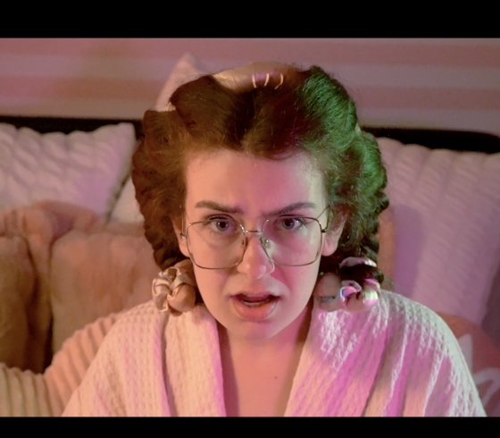 A woman in rollers staring at the camera in distress