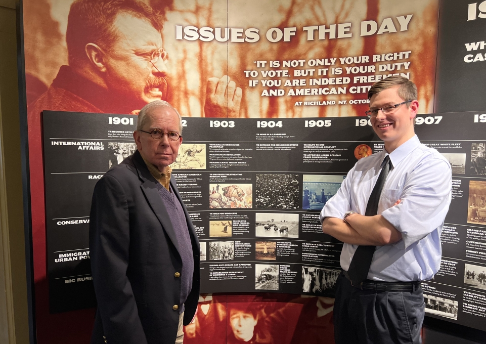 Stanton Hudson and Jacob Riedel in front of a historical sign